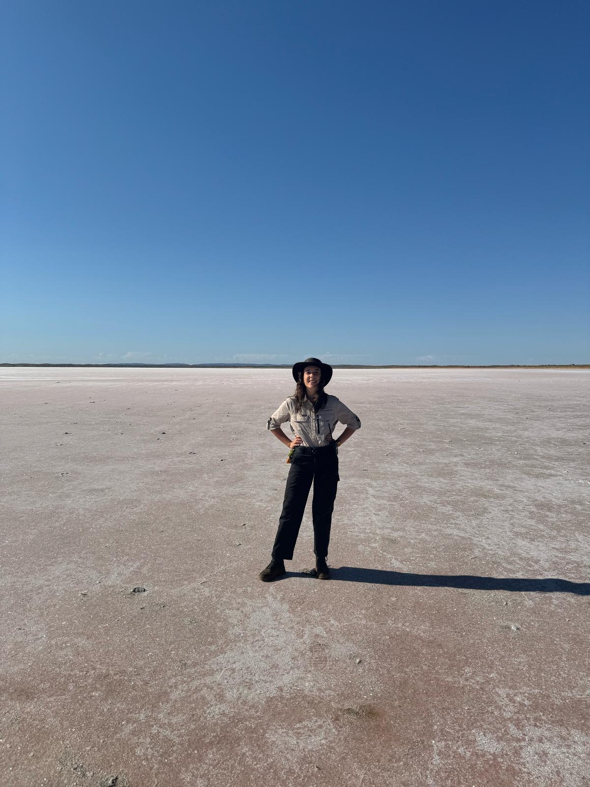 Rachael at Mt Conner, on one of the only assessable salt lakes in the red centre, the sale appears pale pink and white with a strong contrast to the bright blue sky. Rach is posing in the distance with nothing around her for miles.
